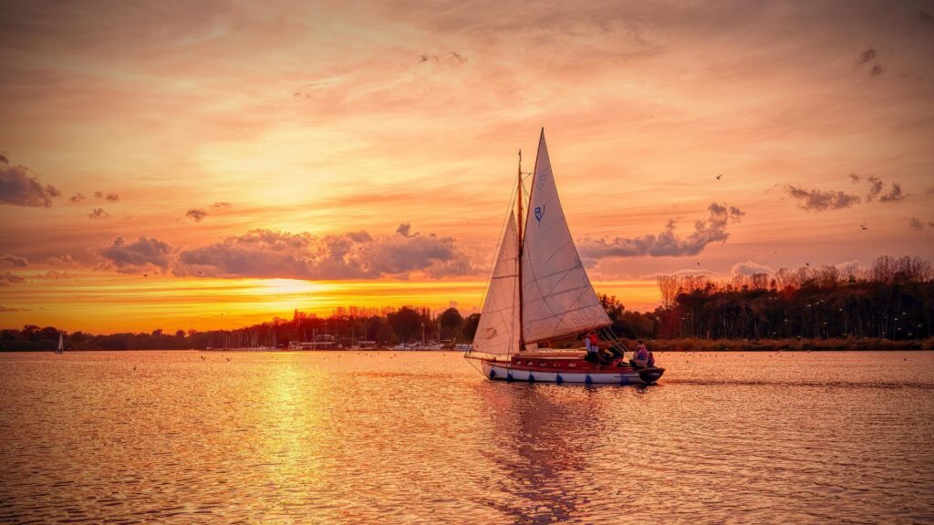 Segelboot auf dem Wasser bei Sonnenuntergang für DUFTGENUSS Lebensfluss – Wege aus dem Stress und innerer Unruhe.